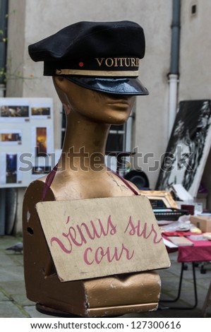 Female mannequin wearing a black driver cap. Still life at flea market in Paris.