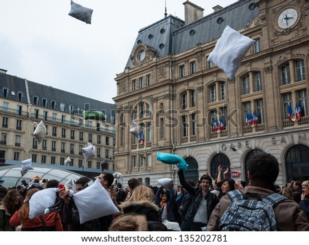 PARIS - APRIL 6: Participants of pillow fight throw up pillows to sky at the end of the event on April 6, 2013 in Paris, France. This year International Pillow Fight Day was celebrated  on April 6.