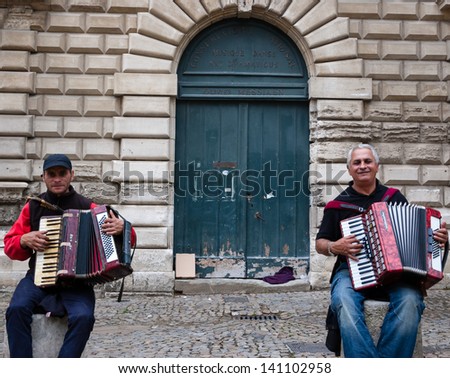 AVIGNON, FRANCE - APRIL 30: Two unidentified street musician near doors of National Music School  as seen on April 30, 2013 in Avignon, France. Hundreds of buskers perform on the streets in France.
