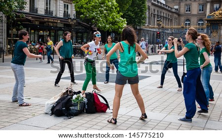 PARIS - JULY 6: Unidentified young women participate in fitness flashmob near Palais de Justice on July 6, 2013 in Paris, France.