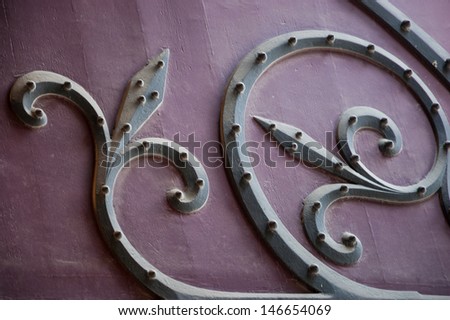 Old forged iron ornament on church gate. Outdoors. Notre Dame de Paris, France.