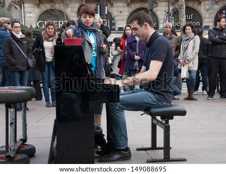 PARIS - APRIL 7: Unidentified pianist play before public outdoors and unidentified girl puts money  on April 7, 2013 in Paris, France. Dozens buskers perform on the streets and in the metro of Paris.