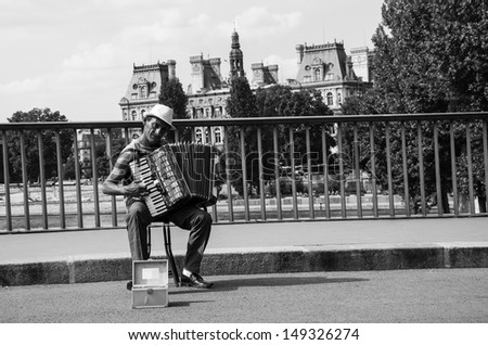 PARIS - JULY 6: Unidentified senior musician plays accordion on the bridge near  Hotel de Ville on July 6, 2013 in Paris, France. Dozens buskers perform on streets of Paris.