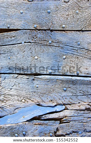 Old blue wooden texture with nail heads and cracks.