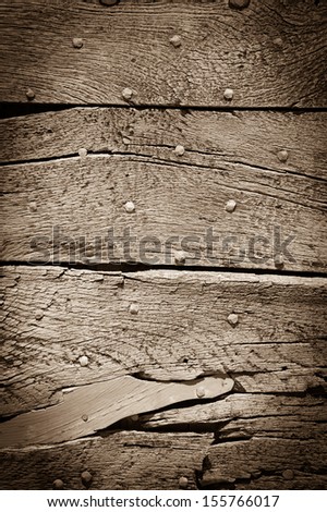 Old sepia wooden texture with nail heads and cracks.  Shadowed angles.