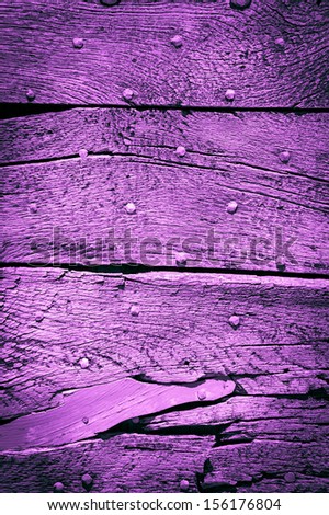 Old violet wooden texture with nail heads and cracks. Shadowed angles.