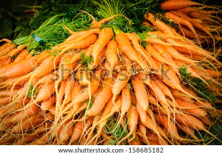 Fresh sweet carrots at local farmer market in Paris. Shadowed angles.