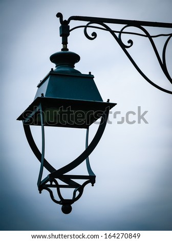 Vintage lantern with water drops after rain. Loneliness concept. Shadowed angles.