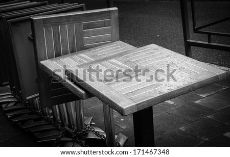 Gathered and locked cafe tables with rain drops. Black and white.