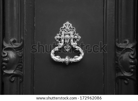 Royal Style Doorknocker On Wooden Door. Black And White.