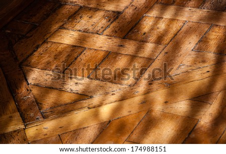 Old parquet floor in the morning light. Game of light and shadow.