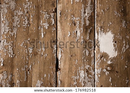 Texture of weathered wooden lining boards with peeling paint and rusty nail heads.