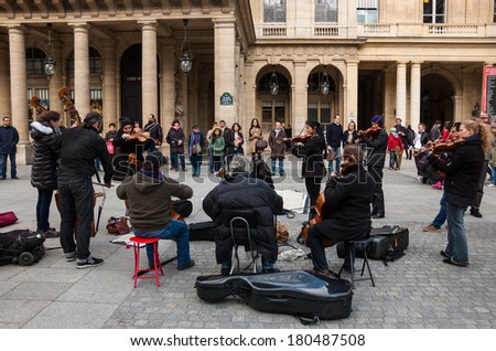 PARIS, FRANCE - MARCH 2, 2014: Small string orchestra plays at Comedie Francaise square before audience consisting mainly of tourists. Dozens buskers perform on the streets and in metro of Paris.