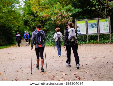 PARIS, FRANCE - OCTOBER 26, 2013: Unidentified people walk with sticks in (Nordic walking) Vincennes forest of Paris. Medical studies show that walking can reduce the risk of stroke in elderly people.