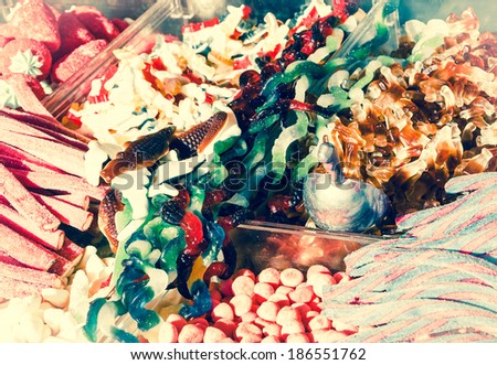Collection of the colorful gummy and marshmellow candies at market. Toned image. Vintage food background. Bleached angles.