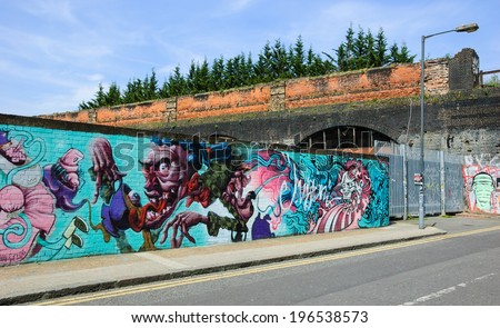 LONDON, ENGLAND, UK - MAY 4, 2014: Graffiti illustration for Alice in Wonderland on the wall in Brick Lane area. Urban art in this area attracts tourists from all over the world.