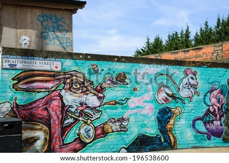 LONDON, ENGLAND, UK - MAY 4, 2014: Graffiti illustration for Alice in Wonderland on the wall in Brick Lane area. Urban art in this area attracts tourists from all over the world.