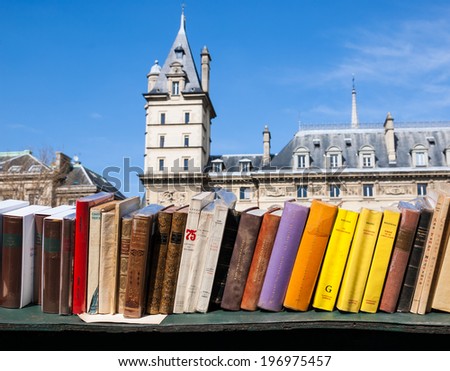 PARIS, FRANCE - APRIL 20, 2013: Bouquiniste stands over Seine river. Selling books on the banks of the Seine began around the 16th century.