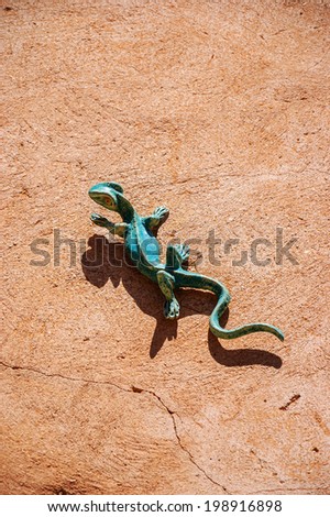 Funny ceramic lizard attached to the stucco wall of rural house. Architectural detail of typical house in Provence (France).