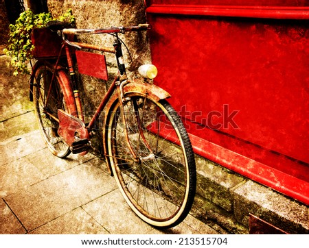 Rusty vintage red bicycle leaning with on red wooden board (useful for entering a text advertisement, menu etc) and carrying plants in wooden box as decoration. Retro aged photo with scratches.
