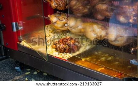 Rotisserie chicken and potatoes near the entrance to the butcher shop in Paris (France).