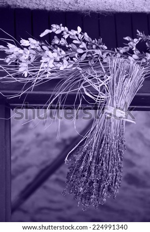 Hanging bouquet of dry lavender. Rustic decoration of old farm house in Provence (France). Aged photo.