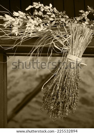Hanging bouquet of dry lavender. Rustic decoration of old farm house in Provence (France). Aged photo. Sepia.