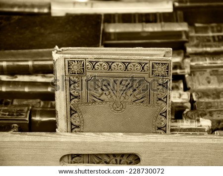 Old books for sale at flea market in Paris (France). Aged photo. Sepia.