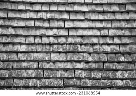 Old traditional wooden tiled roof. Aged photo. Black and white.