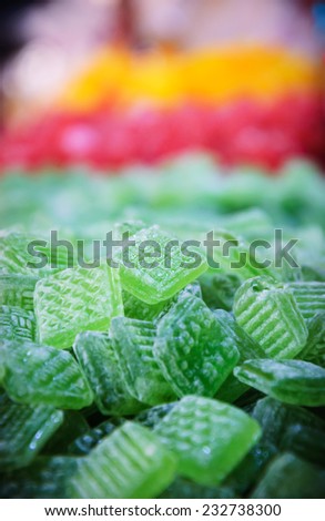 Square mint candies and  other lozenges  at Christmas food market in Paris. Selective focus on the  candy at the top of the pile.