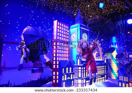 PARIS, FRANCE - NOVEMBER 23, 2014: Colorful Christmas decoration (doll flying with umbrella in London sky) by Burberry in windows of Printemps department store attracts Parisian children and tourists.