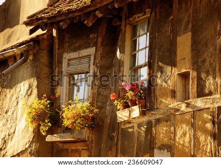 Old half timbered house house decorated with flowers in medieval town Provins (Ile-de-France, France) A game of light and shadow in sunny day.