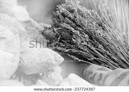 Dried lavender for sale in transparent  bags. Selective focus on dried flowers bunch over the rough  bag. Aged photo. Black and white.