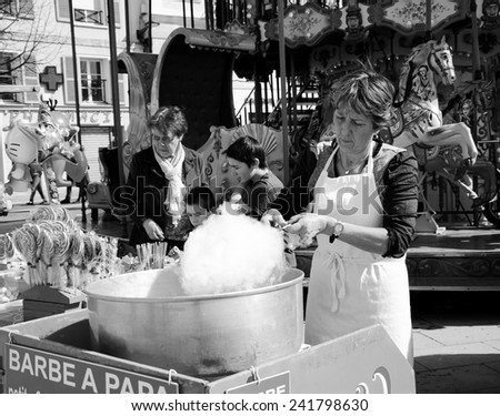 CHARTRES, FRANCE - APRIL 14, 2013: Unidentified vendor prepares candy cotton and the costumers choosing sweets. Cotton candy is one of the most sold sweets at the fairs.