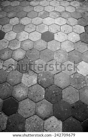 Old terracotta tile floor. Honeycomb pattern. Aged photo. Black and white.