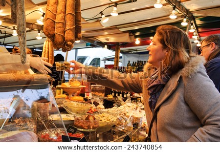 PARIS, FRANCE - JANUARY 26, 2014: Unidentified people buying at Delicatessen stand at organic food market.