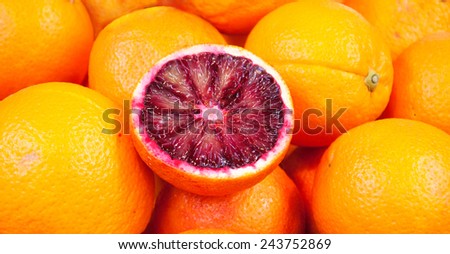 Blood oranges background. Selective focus on the upper part of the cut fruit.