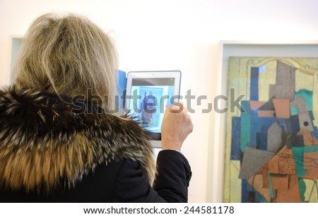 PARIS, FRANCE - JANUARY 4, 2015: Unidentified visitor taking photo of paintings in Picasso museum. This biggest collection of works by Pablo Picasso in the world was reopened to the public in 2014.
