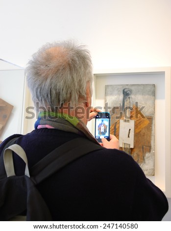 PARIS, FRANCE - JANUARY 4, 2015: Unidentified visitor taking photo of paintings in Picasso museum. This biggest collection of works by Pablo Picasso in the world was reopened to the public in 2014.