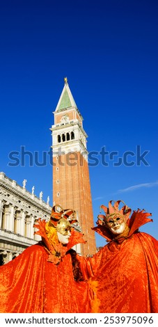 VENICE, ITALY - FEBRUARY 16, 2015:Two masks in St Mark\'s Square square during the traditional Carnival. The Carnival in Venice is annual event which ends on Shrove Tuesday.