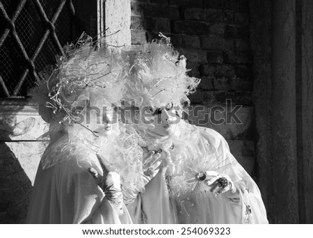 VENICE, ITALY - FEBRUARY 16, 2015:Two Pierrot masks in St Mark\'s Square square during the traditional Carnival. The Carnival in Venice is annual event which ends on Shrove Tuesday.