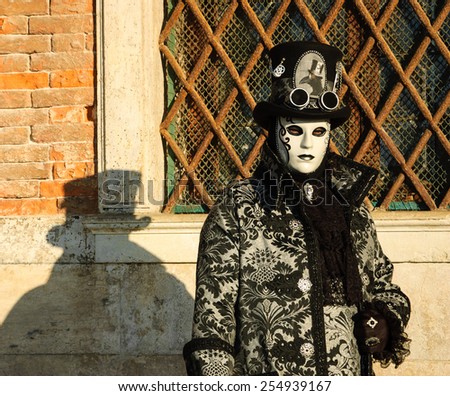 VENICE, ITALY - FEBRUARY 16, 2015: Steampunk mask in sunlight near Doge\'s Palace in St Mark\'s Square during traditional Carnival. The Carnival in Venice is annual event which ends on Shrove Tuesday.