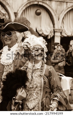 VENICE, ITALY - FEBRUARY 14, 2015:Two seniors in masks at St Mark\'s Square during traditional Carnival. The Carnival in Venice is annual event which ends on Shrove Tuesday.