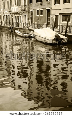 Canal in Venice. Boats and reflection of houses in the water. Aged photo. Sepia.