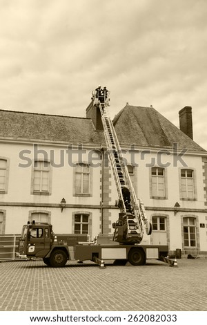 VITRE, FRANCE - JULY 12, 2014: Firemen carry out training exercise near the building at the castle square of Vitre. The castle of Vitre was built in 11th century and rebuilt at 13th century.