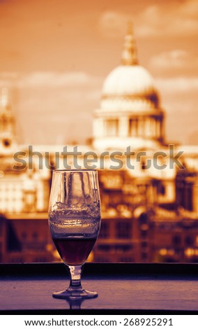 A glass of beer and a view from Tate Modern gallery\'s cafe on St Paul Cathedral. London, England. Toned photo.
