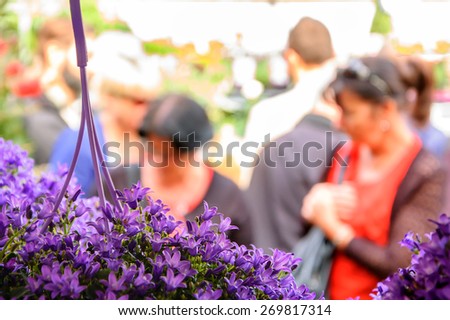 People buying flowers at Columbia Road Flower Market. London, UK. Selective focus. Blurred People.