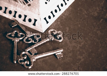 Jewelry box and four vintage keys. Four vintage keys. Retro aged toned photo with scratches. Sepia.
