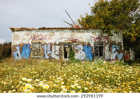 ALGARVE, PORTUGAL - MAY 3, 2015: Ruined farmhouse covered with graffiti. Purchase and renovation of old rural houses in Portugal is becoming popular among Europeans looking for summer houses.