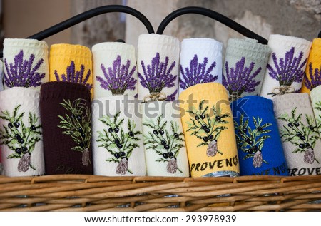 GOURDON, FRANCE - MAY 5, 2013: Colorful kitchen towels with lavender flower and olive branch embroidery and inscription PROVENCE are sold in souvenir shop. Lavender known as one of Provence\'s symbols.